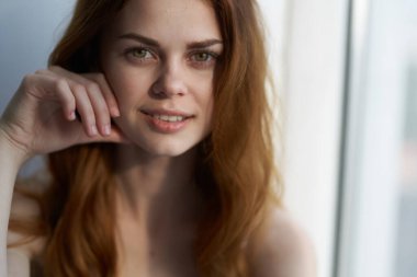 Pencere kenarındaki güzel kadın hafta sonu tatilinde çekici görünüyor.