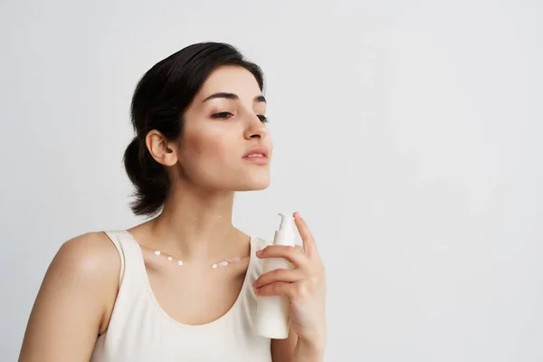 Mulher em branco t-shirt loção nas mãos cuidados com a pele hidratante corpo limpo — Fotografia de Stock