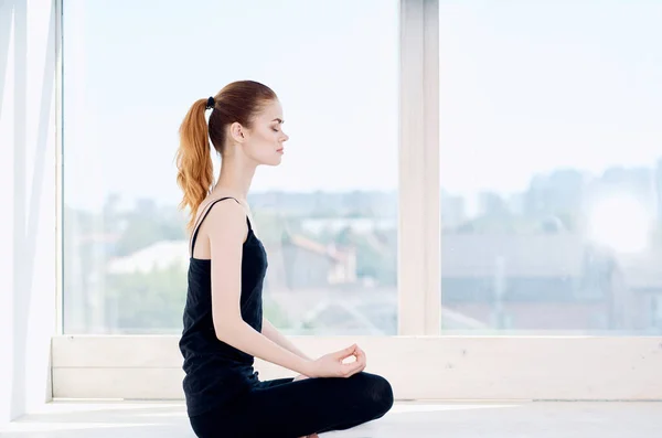Mujer cerca de ventana meditación ejercicio ejercicio fitness — Foto de Stock