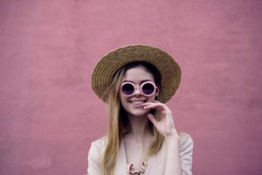 Güzel bir kadın, dışarıda yürüyor. Moda, yaz, pembe duvar gezisi.