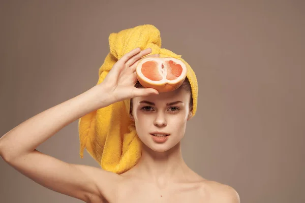 Mulher com uma toalha na cabeça toranja pele limpa na mão vista cortada — Fotografia de Stock