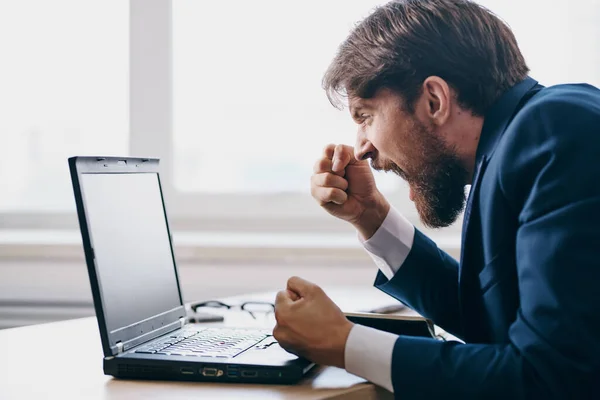 Hombre sentado en un escritorio frente a una red de finanzas portátil profesional — Foto de Stock