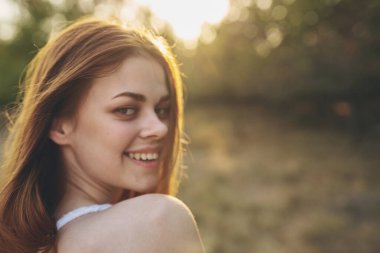 Beyaz elbiseli neşeli kadın doğa temiz hava alıyor.