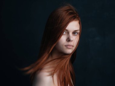 Güzel, kızıl saçlı, çıplak omuzlu, siyah arka plan modasına uygun.