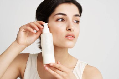 Beyaz atletli güzel esmer, krem rengi cilt nemlendirici kozmetik.