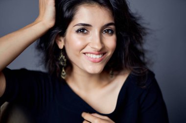 Gevşek saç küpeli güzel bir kadın yakın plan modellik yapıyor.