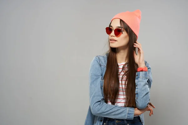 Bonita mulher em denim camisa óculos de sol chapéu rosa posando moda cinza fundo estúdio — Fotografia de Stock