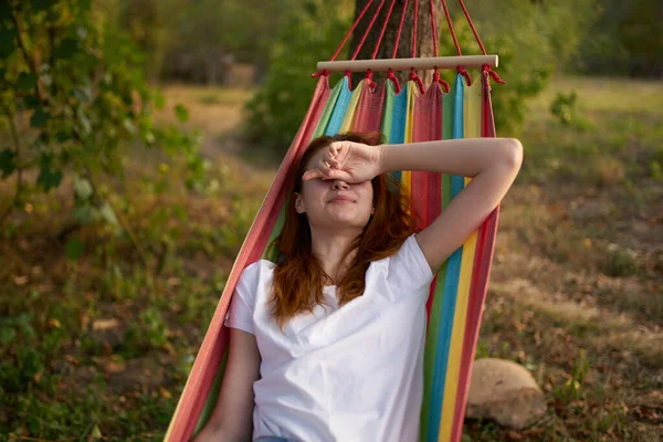 Mulher bonita encontra-se em uma rede ao ar livre natureza árvores — Fotografia de Stock