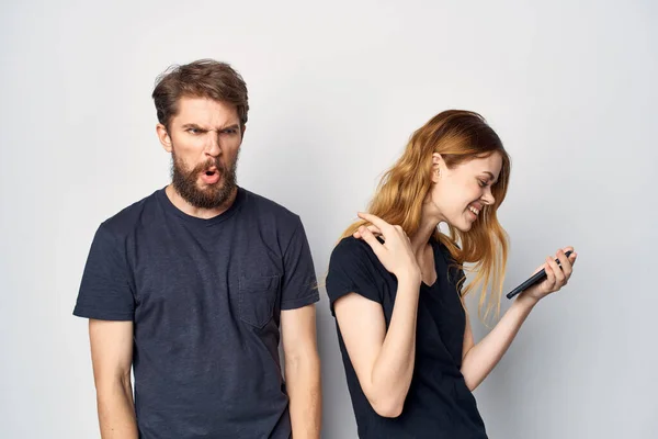 Vidám fiatal pár egy telefon a kezében érzelmek elszigetelt háttér — Stock Fotó