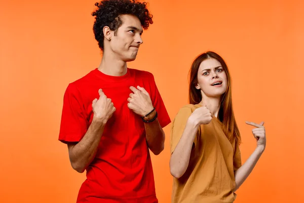 Fiatal pár szórakoztató barátság kommunikáció narancs háttér divat — Stock Fotó
