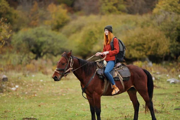Woman hiker riding a horse on nature travel — Stock Photo, Image