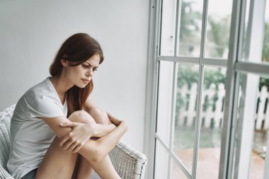 Evdeki üzgün kadın, pencere depresyonu sorunu yaşıyor.