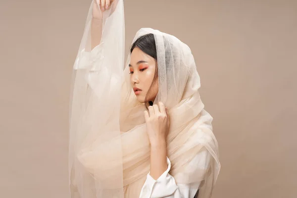 woman asian appearance charm transparent veil beige background