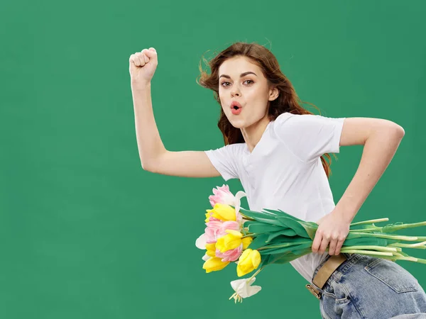 Mulher com um buquê de flores dia das mulheres férias fundo verde — Fotografia de Stock