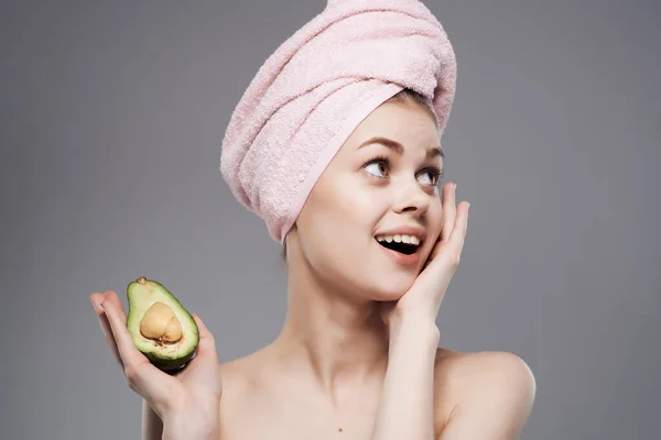 Mulher com uma toalha na cabeça limpa vitaminas da pele isolado fundo — Fotografia de Stock