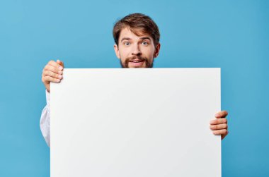 Duygusal adam, elinde mavi arkaplan reklamı olan beyaz model poster.