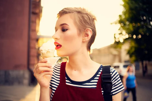 Mooie vrouw buiten eten ijs wandeling — Stockfoto