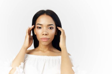 Beyaz elbiseli kadın uzun saçlı poz veriyor.