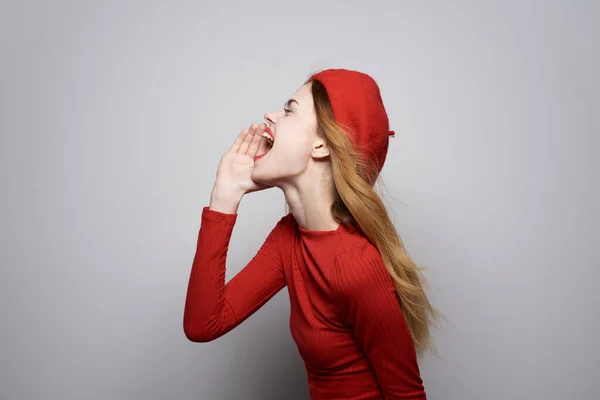 Bonita mulher com um boné vermelho em sua cabeça glamour estúdio posando — Fotografia de Stock