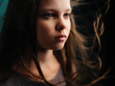 Uzun saçlı bir kız. Duygusal depresyon. Yeşil arka plan.