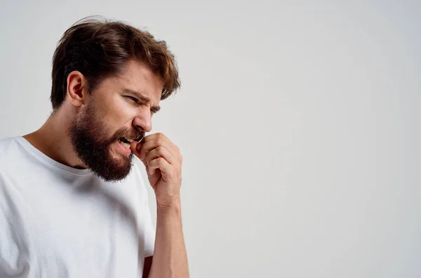 Homme s'accrochant à face douleur dans les dents fond clair — Photo