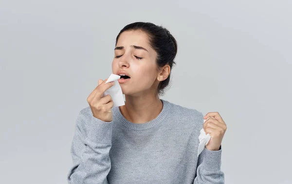 Vrouw met een verkoudheid in een geruite geneeskunde gezondheidsproblemen — Stockfoto