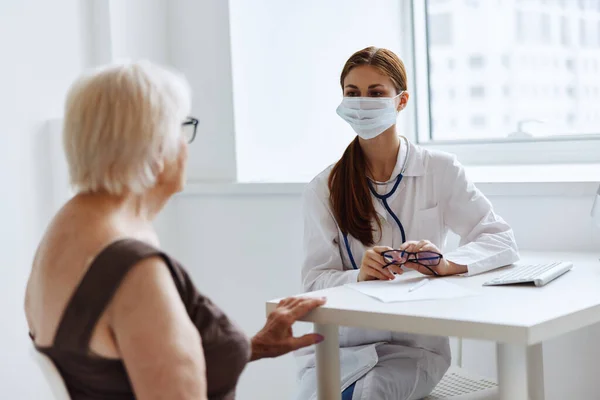 Infermiere in camice bianco discussione con il paziente assistenza sanitaria — Foto Stock