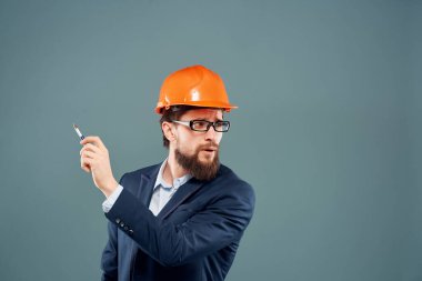 Turuncu kasklı takım elbiseli bir iş adamı.