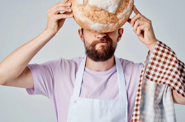 bearded man in white apron cooking food