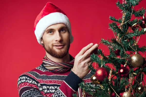 Noel Baba şapkalı neşeli adam Noel süsleri Noel tatili kırmızı arka plan — Stok fotoğraf