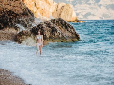 Sahildeki kadın, kayalık dağlarda yürür doğa.