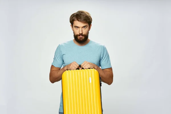 Homem bonito com mala amarela no turismo de viagem de fundo leve — Fotografia de Stock