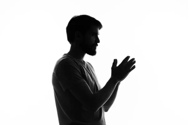 Stock image silhouette of a man in the shadows gesture with hands basing studio