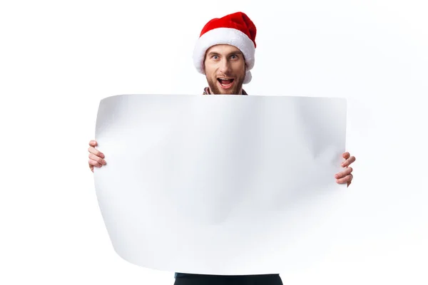 Homme émotionnel dans un chapeau de Noël avec affiche de maquette blanche Noël fond isolé — Photo