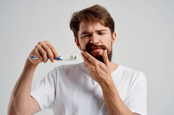 Vousatý muž zubní kartáček v ruce hygiena čisté zuby izolované pozadí — Stock fotografie