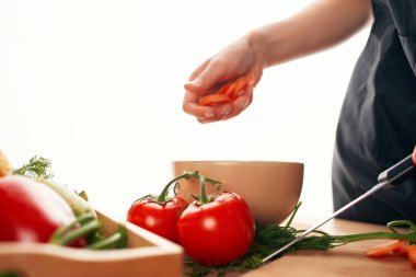 Bıçaklı bir mutfakla kesme tahtasına havuç keserek.