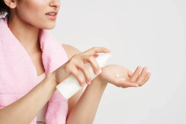 Mujer lleva esto sentado en su mano una toalla rosa en sus hombros cuidado de la piel —  Fotos de Stock