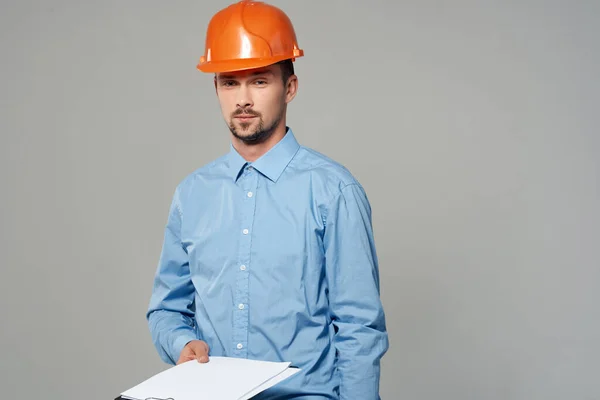 Homem em construção uniforme plantas construtor luz fundo — Fotografia de Stock
