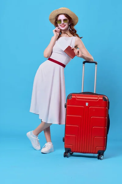 Cheerful woman passenger luggage airport flight blue background — Stock Photo, Image
