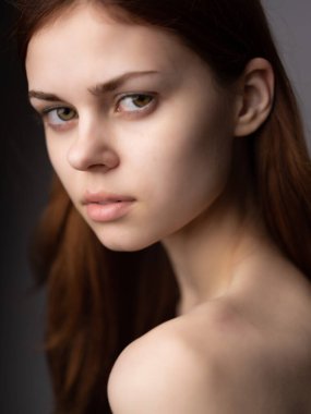 Güzel bir kadın, çıplak omuzlu, açık tenli, çekici, modaya uygun, esmer.