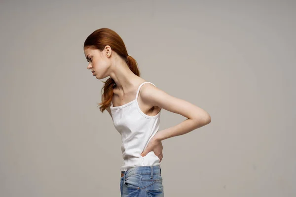 Žena v bílém tričku příznaky bolesti kloubů artritida studio léčba — Stock fotografie