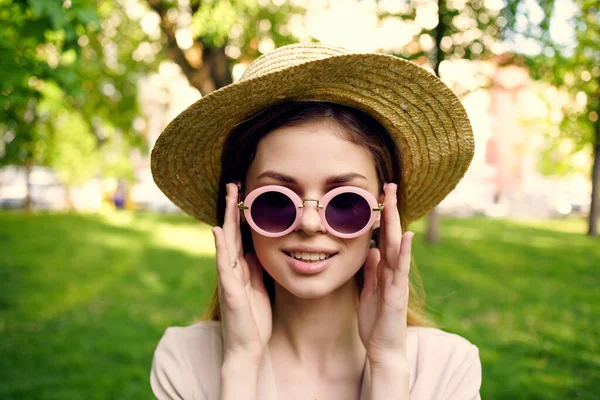 Kobieta okulary przeciwsłoneczne i kapelusz w parku zielony model trawy — Zdjęcie stockowe