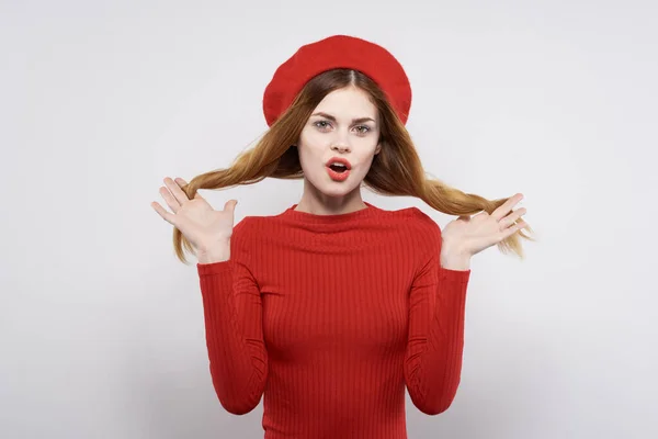 Fröhliche Frau mit einer roten Mütze auf dem Kopf Glamour hellen Hintergrund — Stockfoto