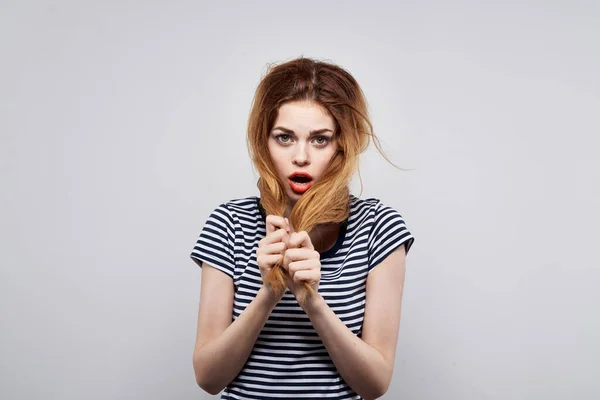 Bella donna in una t-shirt a righe rosso labbra gesto con le mani modello studio — Foto Stock