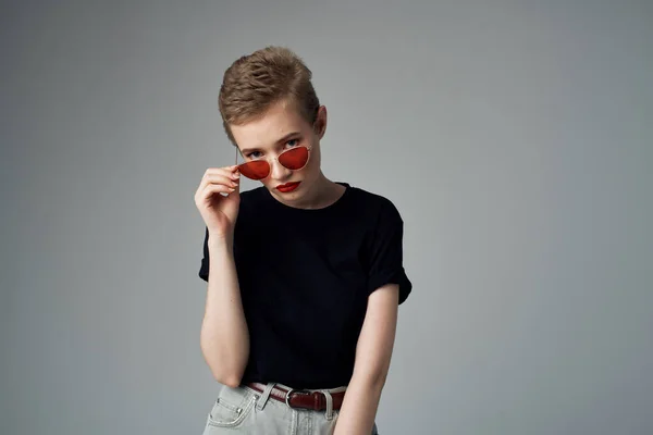 Vrouw in een zwart t-shirt mode donkere achtergrond — Stockfoto