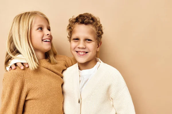 Heureux enfants souriant et posant dans des vêtements décontractés fond beige — Photo