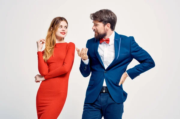 Um homem em um terno ao lado de uma mulher em um vestido vermelho emoções mão gestos isolado fundo — Fotografia de Stock