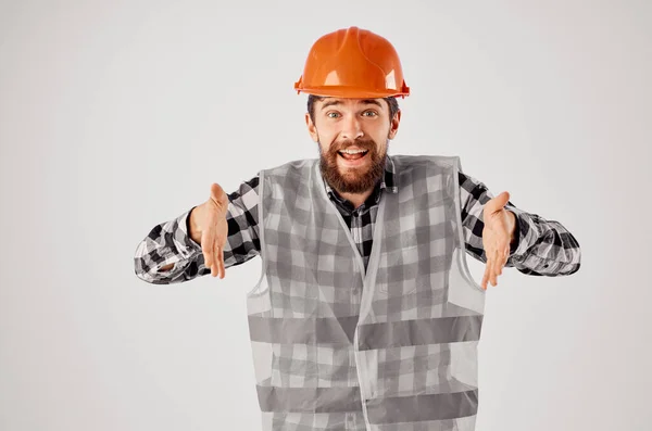 Emocjonalny mężczyzna w pomarańczowy twardy kapelusz konstrukcja profesjonalne światło tło — Zdjęcie stockowe