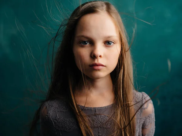 Klein meisje los haar close-up groene achtergrond emoties depressie — Stockfoto