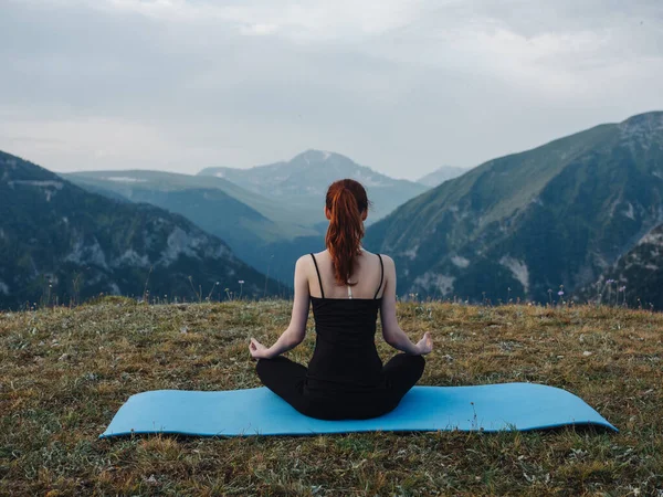 Kadın doğada meditasyon yapıyor. Barışçıl özgürlük dağlarında. — Stok fotoğraf
